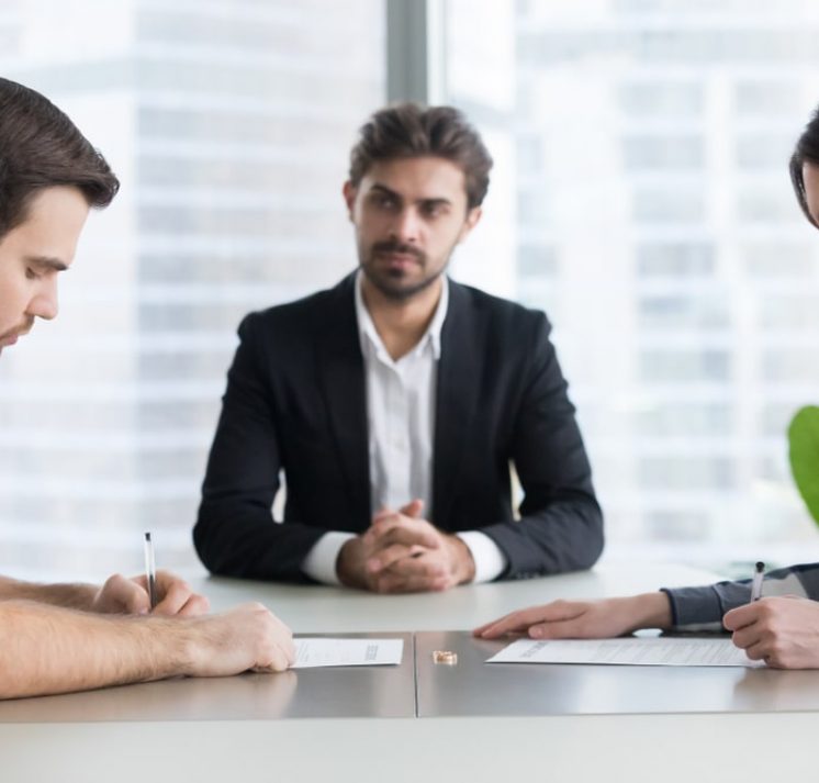 Lawyer signing a contract with the couple — Hannaway Lawyers Pty Ltd