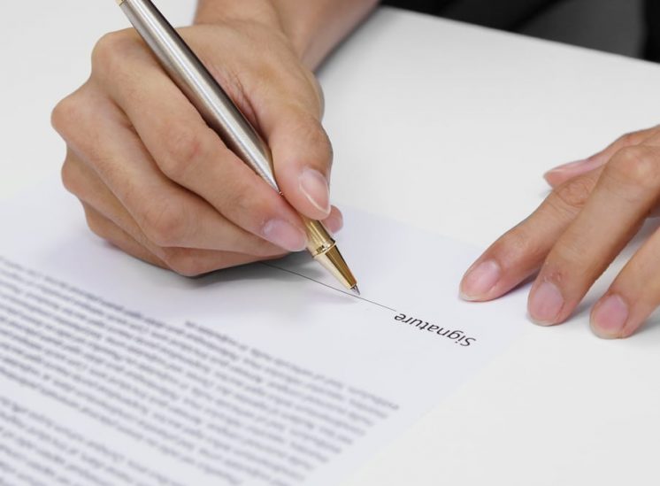 Man signing a contract — Hannaway Lawyers Pty Ltd